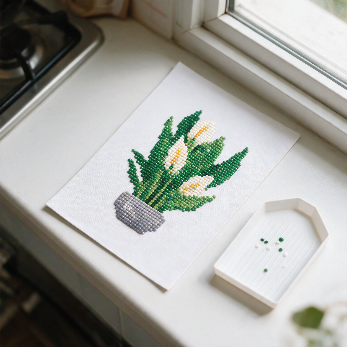 The Lush Edit diamond painting kit: peace lily canvas on a kitchen windowsill